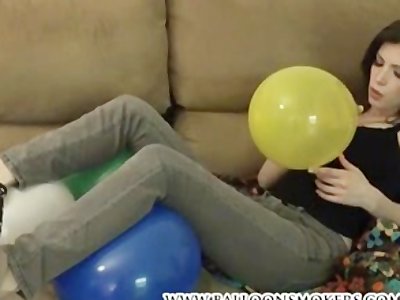 Tattooed teen blowing up and playing with balloons